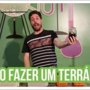 Foto de rapaz com miniterrário na mão com cenário de laboratório de fundo. Na parte inferior da foto escrito: "Como fazer um terrário?"