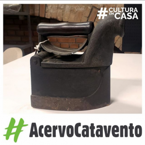 Foto de um ferro preto em cima de uma mesa branca