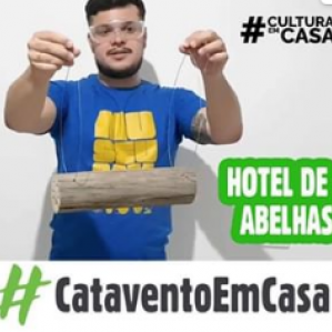Homem de camiseta azul e óculos segurando uma madeira com uma linha transparente