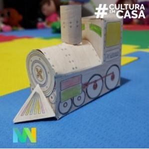 Foto de uma locomotiva de papel na cor cinza em cima de uma mesa com detalhes azul e amarelo