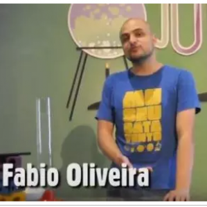 Na foto, com cenário de laboratório, um rapaz de camiseta azul. Na parte inferior da foto escrito: Fábio Oliveira