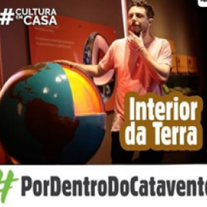 Homem com camiseta na cor rosa ao lado de um globo terrestre
