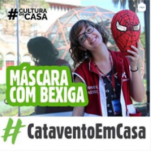 Foto de uma mulher com colete vermelho sorrindo e segurando uma máscara 