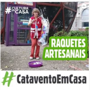 Foto de uma mulher com roupa vermelha em um jardim segurando uma raquete em sua mão