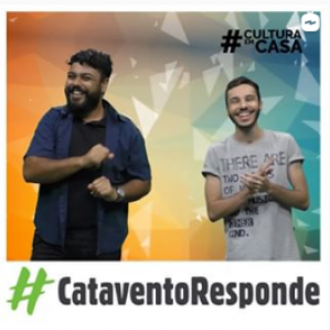 Foto de dois homens sorrindo e gesticulando. Ao fundo uma parede colorida