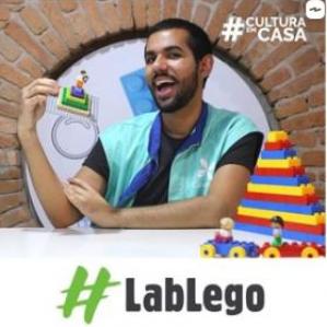 Homem segurando uma pirâmide montada a partir de peças Lego