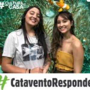 duas mulheres sorrindo. Ao fundo ilustração de um mar