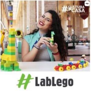 mulher sorrindo e segurando um dinossauro feito de peças de Lego
