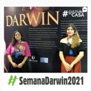 duas mulheres, uma loira e outra morena, ao fundo um painel com