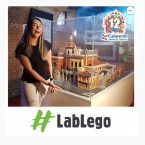 Mulher loira e ao fundo o Museu Catavento feito em Lego