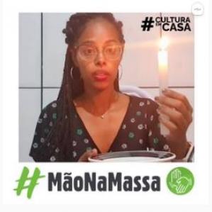 Mulher negra de óculos com uma vela na mão