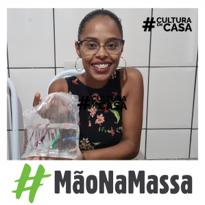 Mulher de óculos sorrindo, segurando um saco plástico
