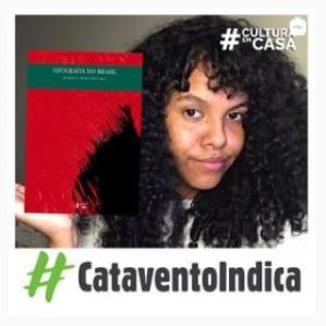 Mulher de cabelos cacheados sorrindo levemente