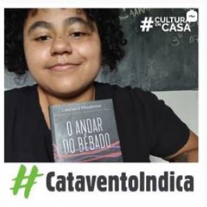 Mulher negra sorrindo, segurando um livro