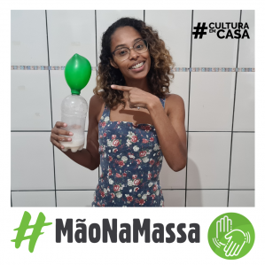 Mulher negra segurando uma garrafa com uma bexiga na ponta