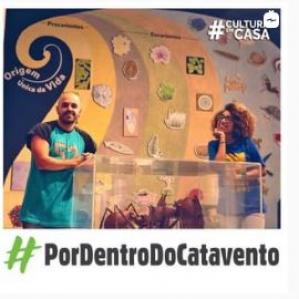 Homem e mulher sorrindo e apoiados numa caixa onde embaixo há uma formiga gigante