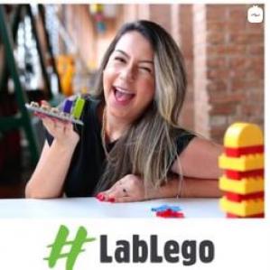 Mulher sorrindo e com Lego na mão