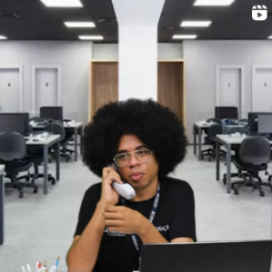 Homem negro de cabelo black segurando um telefone